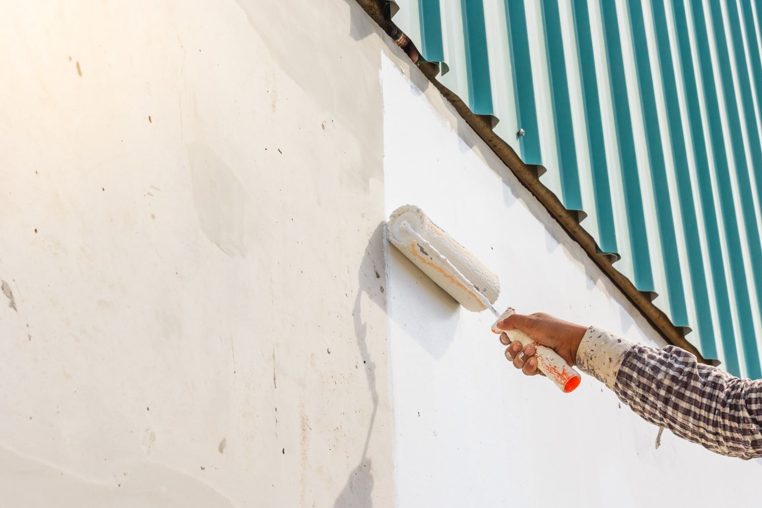 Une personne qui utilise un rouleau de peinture sur un mur