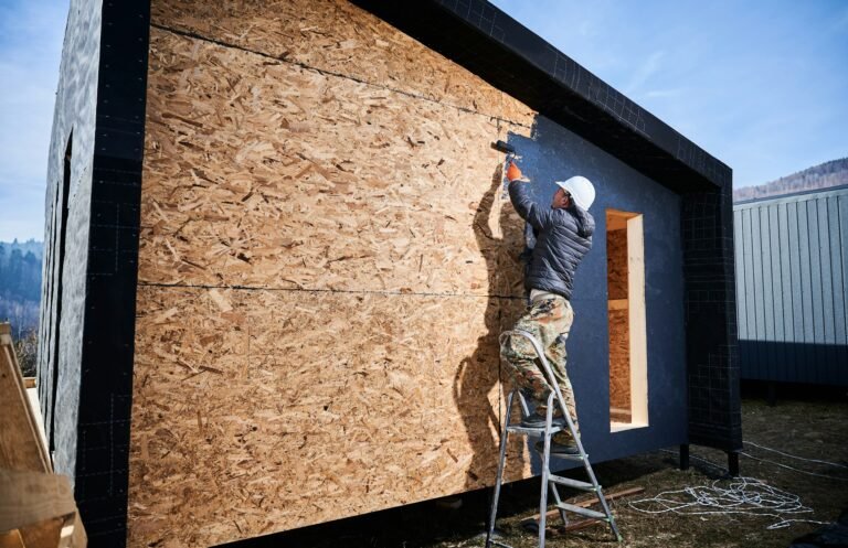 Peintre masculin utilisant un rouleau à peinture, effectuant des travaux de peinture extérieure